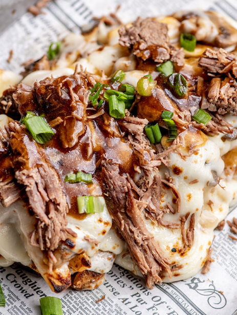 Pub Poutine from London Street Eats by The Pub at Element Eatery food hall, featuring crispy British chips topped with melted cheese, shredded beef, gravy, and green onions on a newspaper-lined tray