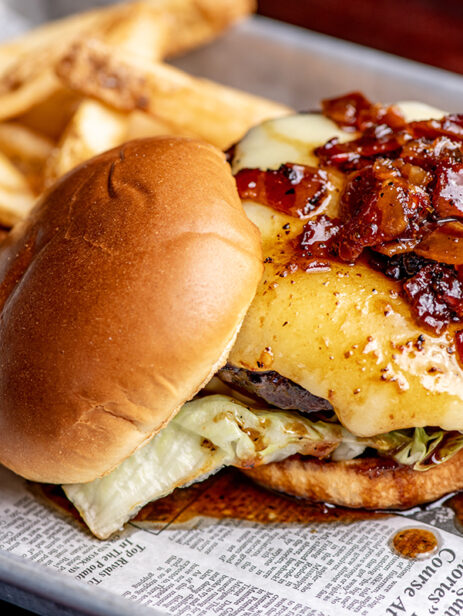 Bacon Jam Burger with melted cheese and lettuce, served with fries on a newspaper-lined tray from London Street Eats by The Pub at Element Eatery food hall