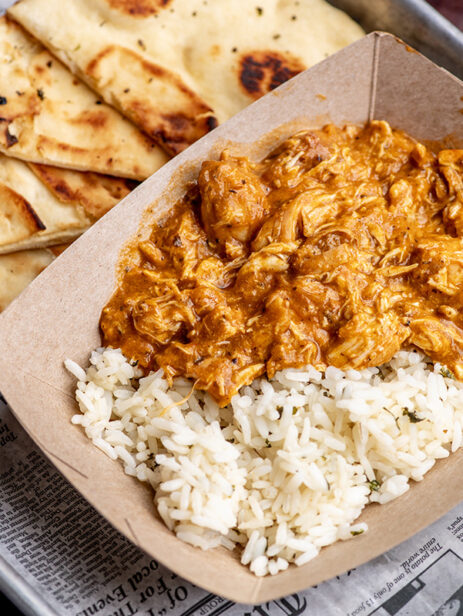 Chicken Tikka Masala from London Street Eats by The Pub at Element Eatery food hall, served with basmati rice and naan on a newspaper-lined tray